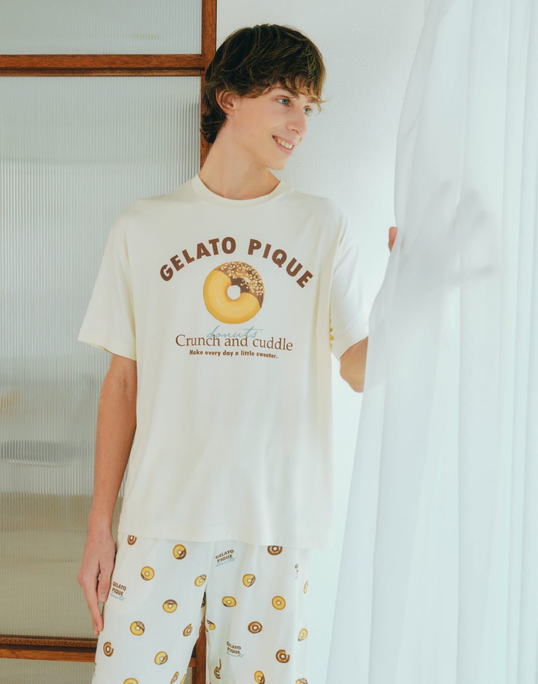 【HOMME】ドーナツワンポイントプリントTシャツ&【HOMME】ドーナツ総柄ハーフパンツを着用した男性