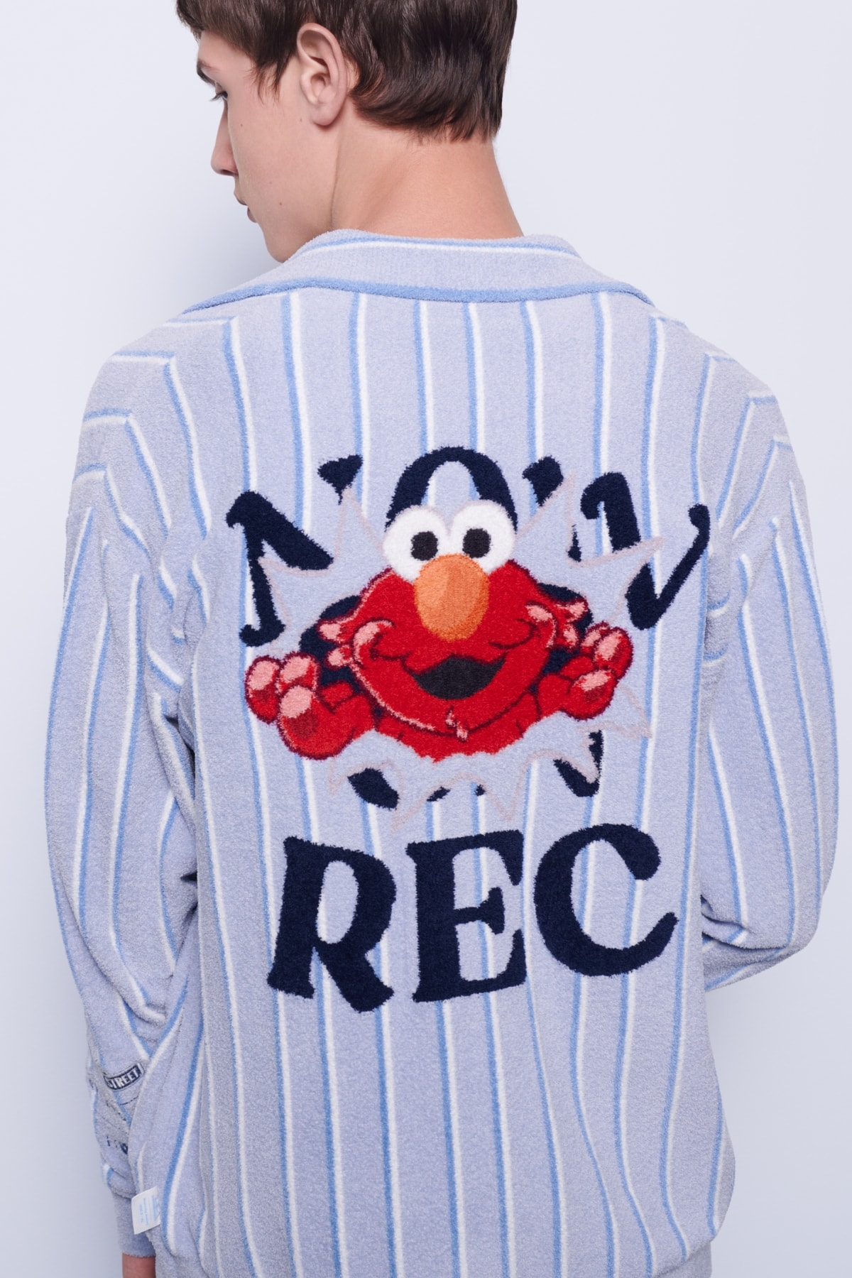 背中に NOW ON REC と刺繍された野球シャツの後ろ姿