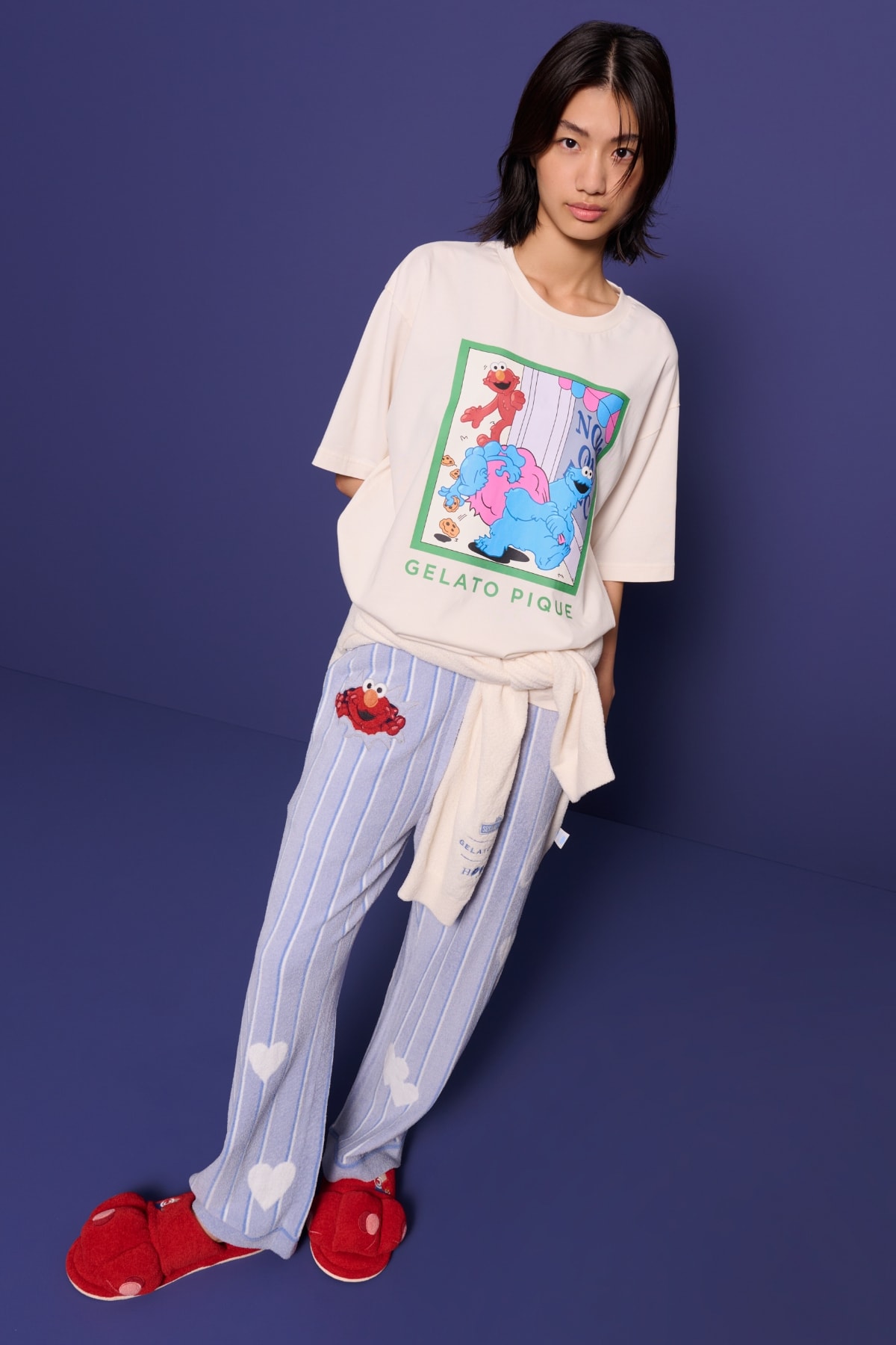 グレーのセットアップを着て座る女性モデル