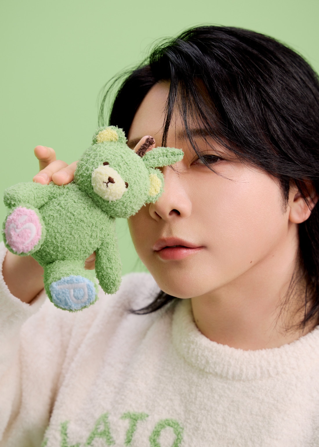 グリベアのぬいぐるみを顔の横に持つ大森元貴さん